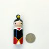 Queen of Hearts peg doll standing next to a quarter for size