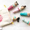5 wooden mermaid peg dolls laying down coming out of a bag. Quote from the little Mermaid. 1 pale skinned with blond hair, 1 pale skinned with a brown top knot, 1 medium skinned with brown pigtails, 1 medium skinned with black double buns.