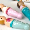 close up of 5 miniature mermaid toys laying down coming out of a bag. 1 pale skinned with blond hair, 1 pale skinned with a brown top knot, 1 medium skinned with brown pigtails, 1 medium skinned with black double buns.