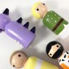6 royal peg dolls set laying down, coming out of a bag. 1 pink queen, 1 orange king, 1 yellow princess, 1 green peince, 1 blue knight, 1 purple dragon
