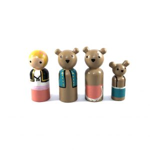 Three Bears wooden figures standing in a row. 1 goldilocks, 1 Papa Bear, 1 Mama Bear, 1 Baby Bear