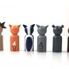 back view of 6 woodland animal toy figurines standing in a row. 1 deer, 1 fox, 1 skunk, 1 raccoon, 1 bear, and 1 rabbit