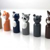 side view of 6 woodland animal toy figurines standing in a row. 1 deer, 1 fox, 1 skunk, 1 raccoon, 1 bear, and 1 rabbit
