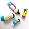 4 wooden family toys laying down. 1 mother, 1 boy, 1 girl, and 1 dad