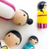 close up of 4 wooden family toys laying down. 1 mother, 1 boy, 1 girl, and 1 dad