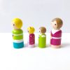 side view of 4 small toy family figures standing in a line. 1 mother, 1 boy, 1 girl, and 1 dad