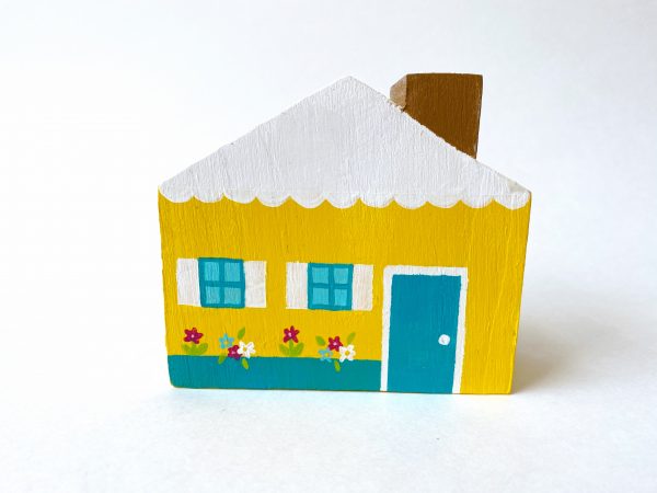 1 yellow, wooden peg doll house standing.