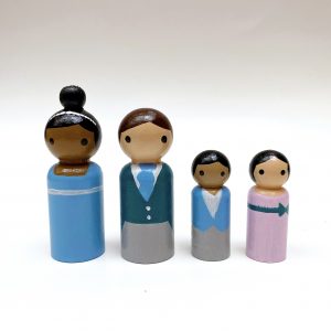 4 wooden vintage inspired Peg dolls standing in a row. 1 African American woman, one pale skinned man, 1 medium toned boy, 1 pale skinned girl all dressed in 19th Century Aristocrat attire.