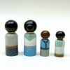 back view of 4 old style wooden toys standing in a row. 1 medium skinned man with black hair, 1 pale skinned woman with black hair, 1 pale skinned boy with brown hair, 1 dark skinned girl with black hair.