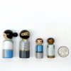 4 pioneer peg dolls standing in a row next to a quarter for size. 1 medium skinned man with black hair, 1 pale skinned woman with black hair, 1 pale skinned boy with brown hair, 1 dark skinned girl with black hair.